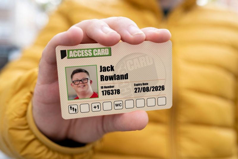 A man showing his Access Card, which displays icons relating to his personal access requirements